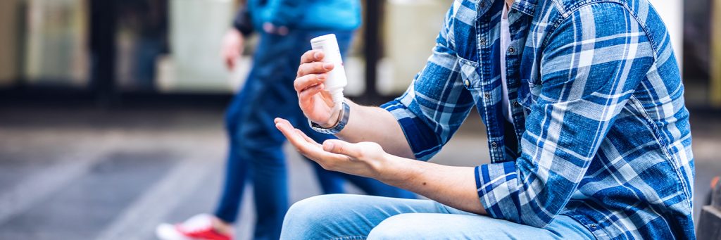 male applying sanitizer to hands