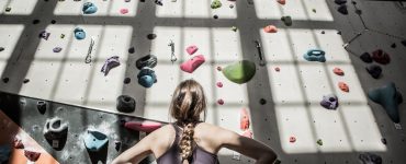 Woman studying a climbing wall strategy