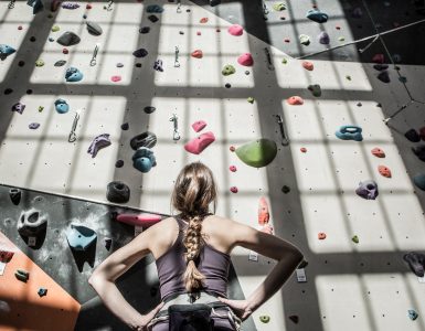 Woman studying a climbing wall strategy